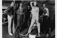 Lexihaunted’s hot girlfriend strikes a pose by a custom dragster. Whichever is hotter? The girl, hands down!